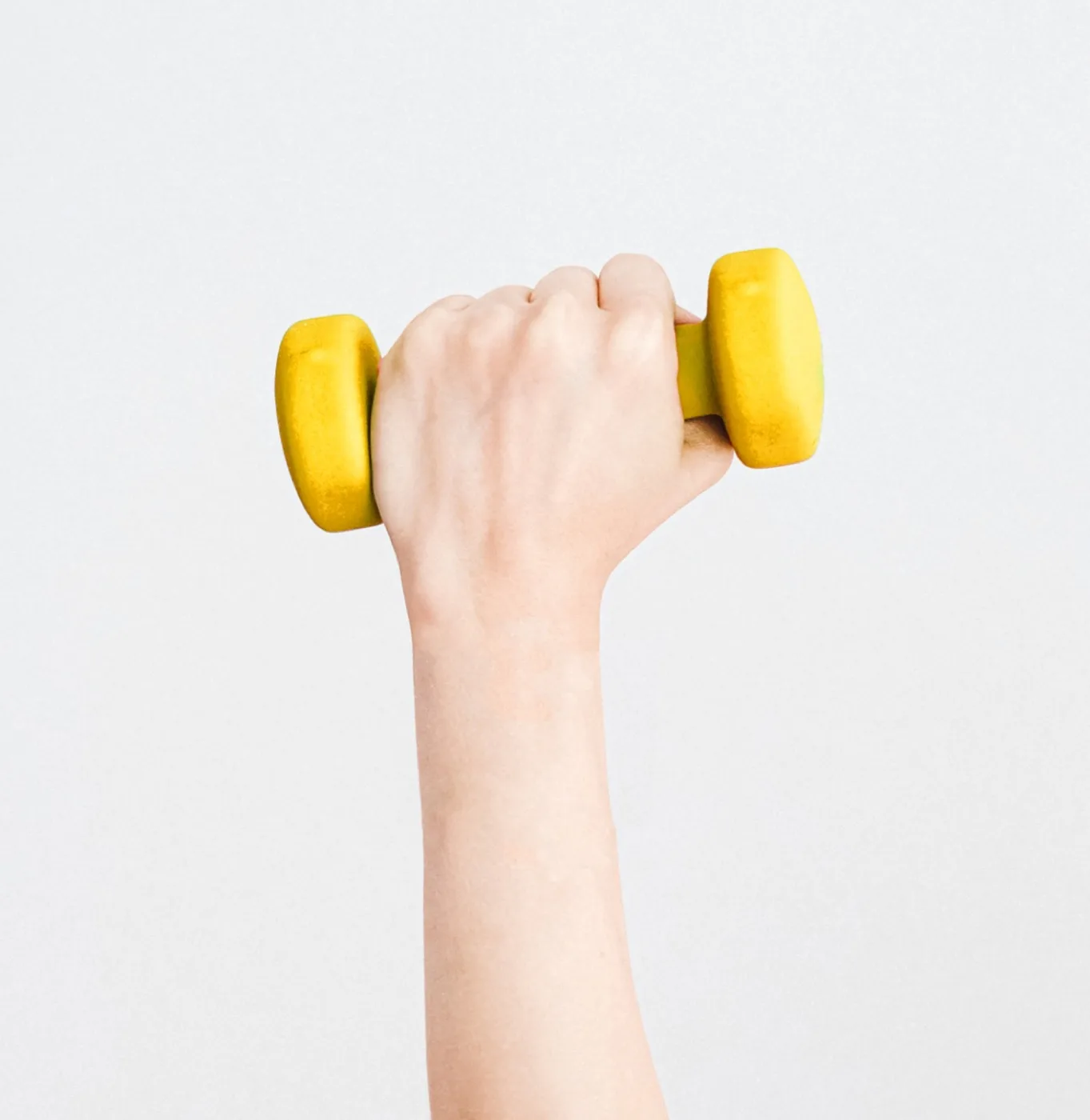 Hand holding a dumbbell — strength sports put load on the elbow, shoulder and wrist